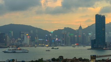 Hong Kong 'dan gece geçişi, Kowloon Körfezi' nden hava görüntüsü şehir merkezindeki zaman dilimi büyük gemi ve çatıdaki kuleler.
