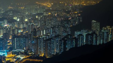 Fei ngo shan Kowloon Tepesi 'nden görüntüler. Gece vakti Hong Kong şehrinin gökyüzü. Parlak pencereli ve arka planda büyük köprüsü olan uzun binalar..