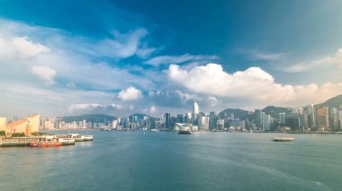 Şehir manzaralı Hong Kong Limanı panoraması. Mavi bulutlu gökyüzü - Victoria Limanı, Victoria Tepesi, Hong Kong Adası ve Kowloon, Hong Kong.