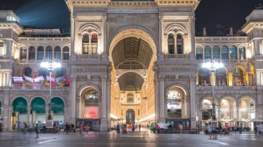 İtalya 'nın Milano kentindeki Vittorio Emanuele II Galerisi' ne gece görüşü. Metro çıkışının yanındaki Meydan Piazza Duomo 'da yürüyen insanlar.