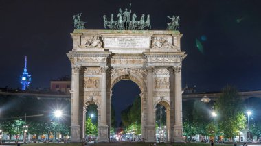 Piazza Sempione 'deki Arco della Pace (Simplon Meydanı' ndaki Barış Kemeri) gece aydınlandı. 1807 ve 1838 yılları arasında inşa edilmiş neoklasik bir zafer kemeridir. Arkaplanda trafik