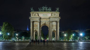 Piazza Sempione 'deki Arco della Pace (Simplon Meydanı' ndaki Barış Kemeri) ön manzara hiperhızlandırılmış gece görüşü aydınlandı. Bu neoklasik bir zafer kemeri. Arkaplanda trafik