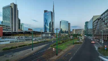 Milan skyline with modern skyscrapers in Porta Nuova business district day to night transition panoramic in Milan, Italy, after sunset. Traffic on the road. Light in windows. Top view from bridge clipart