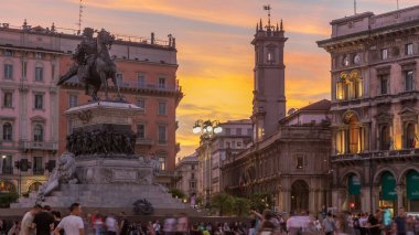 Piazza del Duomo 'dan geceye geçiş zamanı, Milano' nun ana meydanı. Gün batımından sonra Victor Emmanuel Anıtı II. Arkasında saat kulesi olan Giureconsulti sarayı. Milan, İtalya