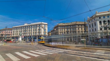 Cordusio Square and Dante street with surrounding palaces, houses and buildings in Italian capital of fashion and luxury. Trams passing by. Monument to writer Giuseppe Parini. Blue sky at summer day clipart