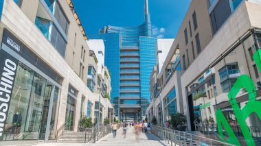 Gökdelen ve Milan finans bölgesine timelapse modern binalarda. Street mağazaları ile. İnsanlar burada yürümeye çalışıyoruz. Mavi bulutlu gökyüzü yaz gün