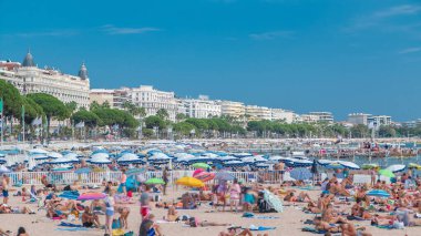 Fransa 'nın güzel bir yaz gününde Fransız Riviera' sında Cannes 'daki renkli eski kasaba binaları ve plajlar. Azur denizi, kumların üzerinde dinlenen insanlar.