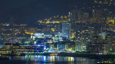 Monte Carlo 'nun şehir manzarası, Monaco, gece vakti. Akşam sisi ve binaların gece aydınlığı. Limandaki yatlar. Kaptan Martin 'den hava görüntüsü