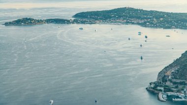 Akdeniz kıyı şeridi Saint-Jean-Cap-Ferrat 'ın havadan görüntüsü. Günbatımında Fransız Rivierası 'ndaki Eze köyünün tepesinden kayıklar ve ortaçağ evleri.