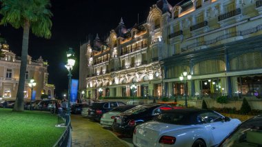 Monte Carlo gecesi hyperlapse timelapse Monaco Grand Casino ile kare. Tarihi binalar çevresinde. Avuç içi tarafında. Otopark ve yolda trafik