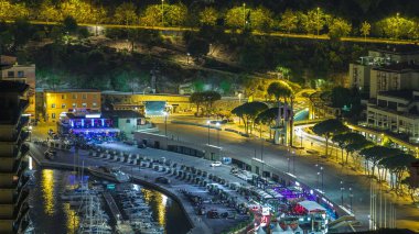 Monte Carlo 'nun şehir manzarası, Monako' da gece saatleri yat ve liman trafiği. Tepelerden gökyüzü görüntüsü.