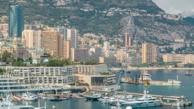 Monte Carlo şehri havacılık panorama zaman çizelgesi. Monaco, Cote d 'Azur limanındaki lüks yatlar, tekneler ve konut binaları. Herkül Limanı tepeden arka planda dağlarla
