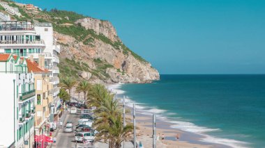 Aerial view on the coastal town of Sesimbra with palms on the street and beach in Portugal timelapse with blue sky and ocean clipart