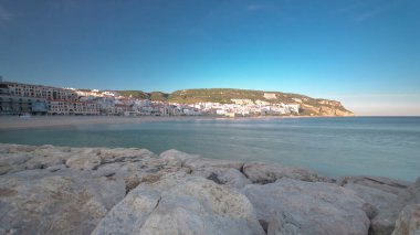 Sesimbra Portekiz 'in küçük bir kasabasında, iskeleden gün batımı tepede gölgeler, panoramik zaman dilimi