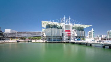 Lizbon Oceanarium, dünyanın en büyük ikinci ve Avrupa'nın en büyük oceanarium. Parque das Nacoes. Portekiz. Mavi gökyüzü ve yeşil su ile Timelapse hyperlapse hyperlapse