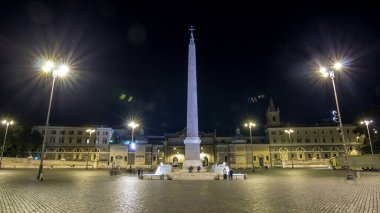 insanlar gece timelapse hyperlapse sırasında piazza del popolo üzerinde merkezi sütununun altında toplanıyor. Işıklı tarihi binalar ile göster