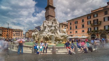 Piazza Navona, the fountain of four rivers timelapse hyperlapse. People sitting around. Cloudy sky. Italy, Rome