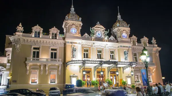 stock image Grand Casino in Monte Carlo night timelapse, Monaco. historical building. Front view with entrance. Palm on the side. Evening illumination