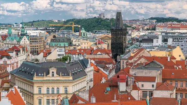 stock image Aerial view of the traditional red roofs of the city of Prague, Czech Republic with the Powder tower and Vitkov Hill in the distance timelapse. Top view from Old Town Hall tower