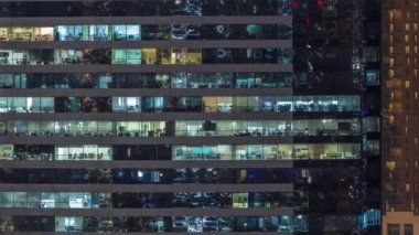 Ofis binalarının camları gece saatlerinde aydınlatılıyor. Cam mimari, şirket binası, parlayan ışıklar.