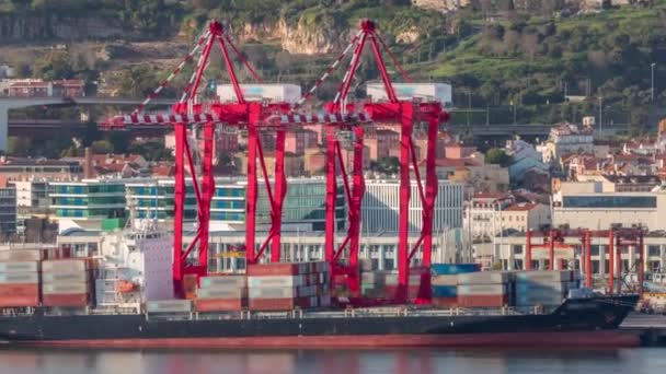 船積みおよび海港のタイムラプスで荷を下す容器の船 ビジネスロジスティック輸入と輸出貨物輸送の航空ビュー ポルトガル リスボン港に赤いクレーンを搭載した貨物船 — ストック動画