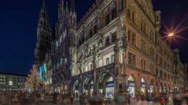 Main facade of the New Town Hall (Neues Rathaus) building at the northern part of Marienplatz day to night transition timelapse in Munich after sunset. Fischbrunnen fountain in front. Bavaria, Germany. clipart