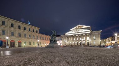 Münih Ulusal Tiyatrosu veya Ulusal Tiyatro Max Joseph Meydanı 'nda günden geceye geçiş zamanlarında. Tarihi opera binası, Bavyera Devlet Operası 'nın evi. Ortadaki heykel. Almanya