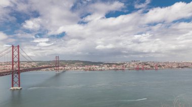 Lizbon şehir manzarasını gösteren panorama 25 Nisan köprüsünün tarihi süspansiyonuyla ve Tagus Nehri zaman dilimiyle, Almada 'daki Cristo Rei' nin bakış açısından Eski Şehir Alfama 'nın havadan görünüşü. Portekiz