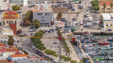 Aerial view of marina and city center timelapse in Setubal, Portugal. Red roofs and waterfront with boats and ships from above. Traffic on the road clipart
