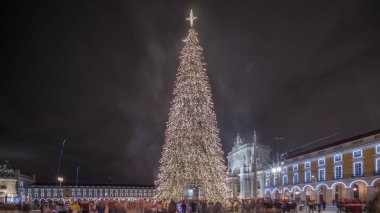 Panorama, Lizbon 'da Noel zamanı Ticaret Meydanı' nın aydınlatıldığını ve süslendiğini gösteriyor. Noel ağacı ve turistlerin cirit attığı bir meydan. Tatil zamanları. Portekiz