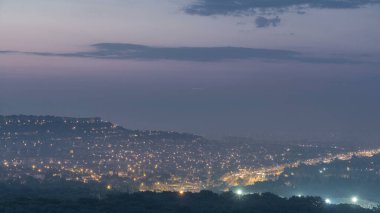 Türkiye 'de gün doğumundan önceki kuşbakışı geçiş zamanı gece gündüz. Hindi. Sabah sisi. Yollarda trafik vardı. Yeşil ağaçlar. Renkli gökyüzü