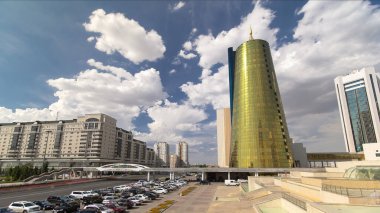 Traffic on the road and car parking timelapse hyperlapse near yellow tower in downtown of Nur-Sultan city, Kazakhstan. Astana city is famous for its diverse modern architecture. clipart