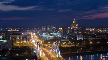 Köprü 'nün yukarısında akşam saatleri ve arka planda bulutlar. Orta Asya, Nur-Sultan şehri, Kazakistan. Şehir havası silüeti. Gece trafiği