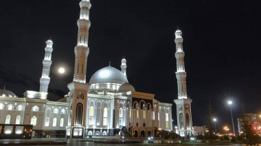 Astana 'daki Hazrat Sultan Camii' ni aydınlattım. Geceleyin dolunay, Nur-Sultan şehri, Kazakistan