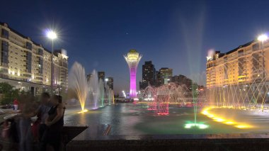 Bayterek Tower and fountain show at night. Bayterek is a monument and observation tower in Astana. Nur-Sultan city, Kazakhstan. clipart