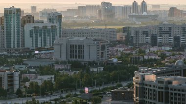 Sis, Nur-Sultan şehri, Kazakistan, Orta Asya 'nın güneş doğuşuyla birlikte şehir merkezi ve merkez iş bölgesi hava sahasının sabah görüntüsünün yükseltilmesi