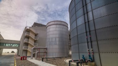 Two silver Water Tanks with fence timelapse hyperlapse. Cooling system. Cloudy sky clipart