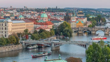 Prag 'daki Vltava Nehri' nin hava akşam manzarası ve trafik ile aydınlanan köprüler. Kuleler ve kuleler. Tekneler ve gemi suda yüzüyor. Hanavsky köşkünden üst görünüm
