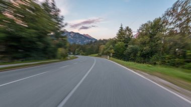 Avusturya, bir güzel sonbahar günü timelapse hyperlapse drivelapse Alpler'de asfalt yolda sürücü. Orman ve dağlar akşam