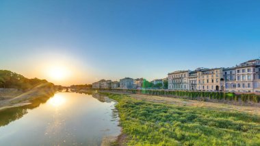 Florence City 'nin günbatımı manzarası, evler, binalar ve Arno Nehri. İtalya 'da gökyüzü çok renkli. Suya bakan Ponte Amerigo Vespucci köprüsünden görüntü