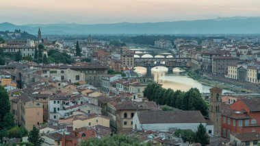 Günbegün Arno Nehri 'nin gökyüzü görüntüsü geçiş zamanı, Piazzale Michelangelo' dan Ponte Vecchio, Floransa, İtalya. Renkli gökyüzü. Akşam sisi aydınlatılmış binaları kapladı