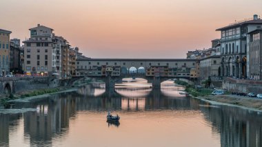 River Arno and famous bridge Ponte Vecchio day to night transition timelapse from Ponte alle Grazie in Florence after sunset, Tuscany, Italy. Reflection on the river with evening illumination clipart