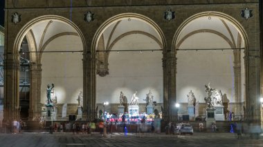 Piazza della Signoria Meydanı 'ndaki Loggia dei Lanzi' nin önündeki insanlar. Gece aydınlatması. Sahnedeki konser. Floransa, İtalya