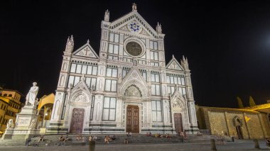 Floransa 'da Santa Croce Meydanı' nda gece vakti yürüyen turistler, Basilica di Santa Croce (Kutsal Haç Bazilikası) ile son sürat gidiyorlar. Kilise ünlü İtalyanların gömüldüğü yerdir..
