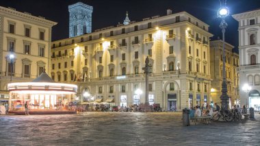 Floransa 'nın tarihi binalarının bulunduğu en büyük şehir meydanlarından biri olan Piazza della β bblica zaman diliminde yürüyen turistler. Arka planda Giotto 'nun Campanile kulesi
