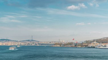 İstanbul 'daki Galata Köprüsü' nden İstanbul Boğazı zaman çizelgesinde turizm gemisi ve feribot trafiği. Arka planda Camlica tepesi olan şehir silüeti bahar günü gün batımından önce
