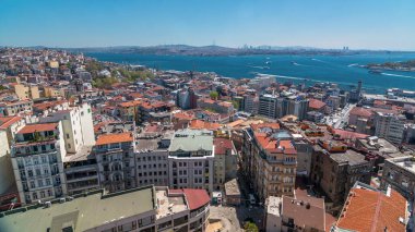 Galata Kulesi 'nden Golden Horn ve Boğaz' a, kırmızı çatıları olan şehir silueti. Altın Boynuz 'un zıt kıyılarında Beyoğlu bölgesi ve Sultanahmet, İstanbul, Türkiye. Güneşli bir günde feribot trafiği