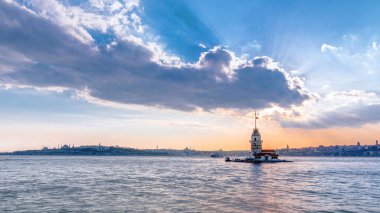 Renkli bulutlar ve istanbul, Türkiye, kiz kulesi Kulesi ışık timelapse güneş ışınları ile gün batımına bakirelerin kule. Bosforus su yansıması ile arka plan üzerinde şehir manzarası
