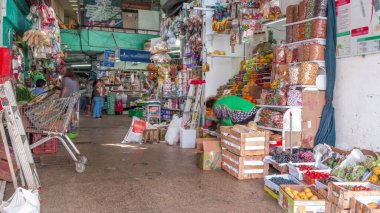 Surquillo Market zaman çizelgesi, Lima, Peru. Lima 'nın en büyük gıda pazarı. Tezgahtaki satıcılar sebze, meyve ve et satıyor.