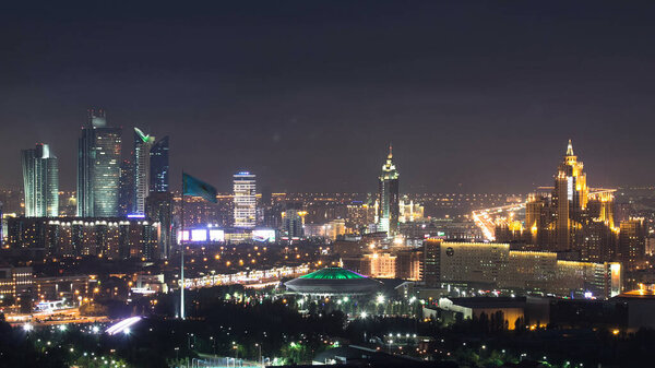 Elevated night view over the city center and central business district with circus and flag aerial timelapse illumination turned on, Kazakhstan, Nur-Sultan city, Central Asia